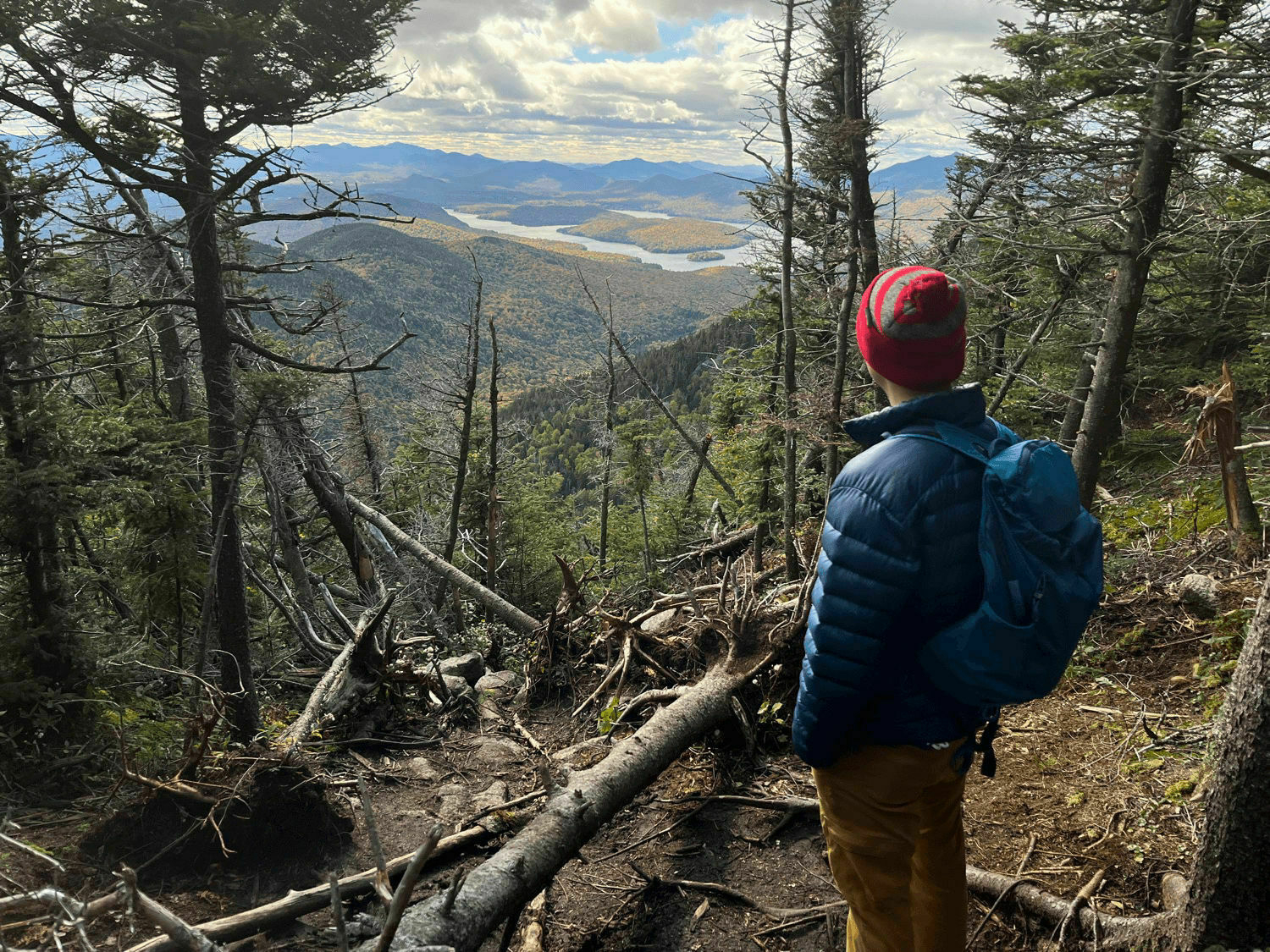 Man overlooking Lake Placid from atop a mountain.