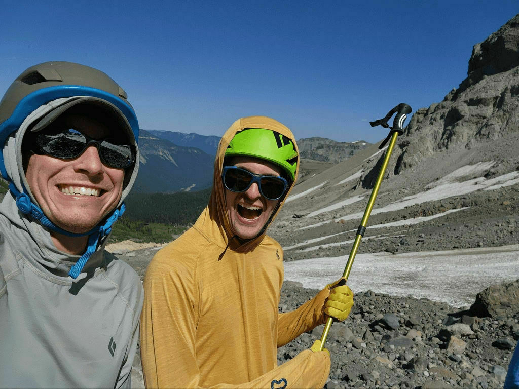 Two men wearing sun hoodies on a frozen landscape.